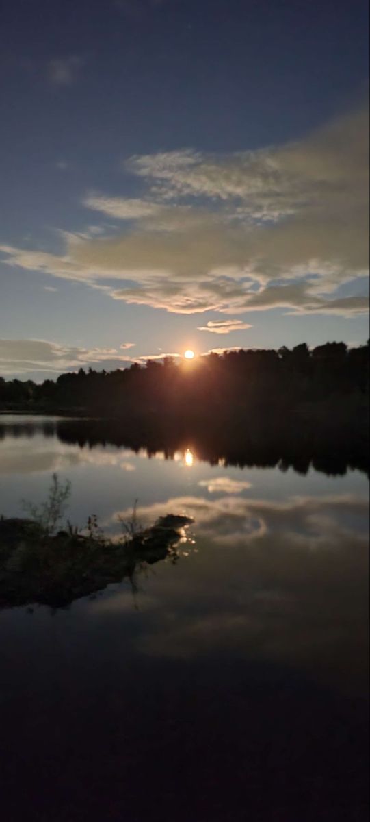 the sun is setting over a body of water