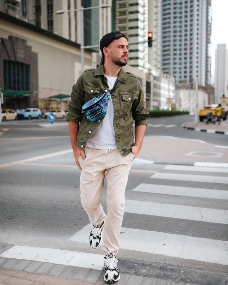 a man standing in the middle of a crosswalk with his hands in his pockets