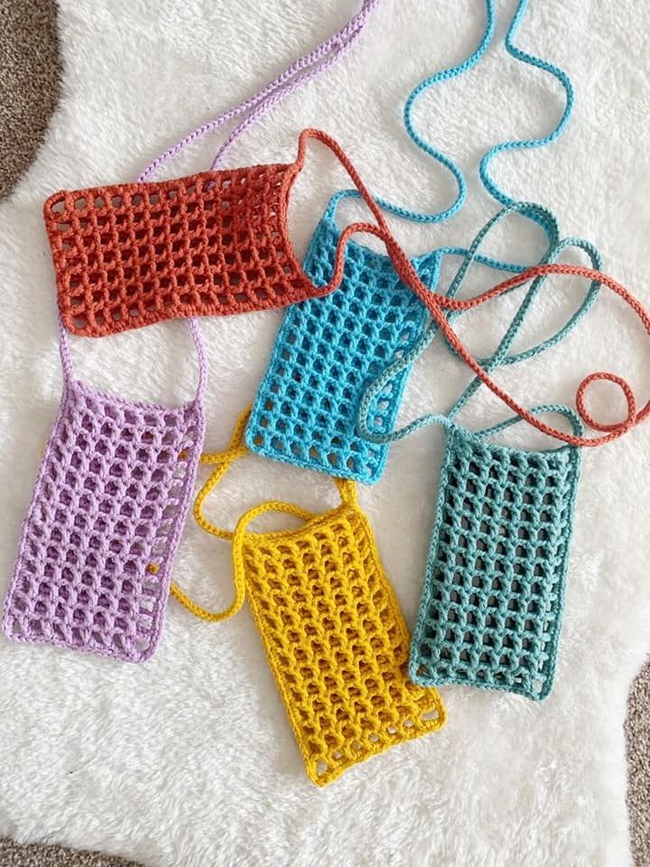 four crocheted purses sitting on top of a white rug