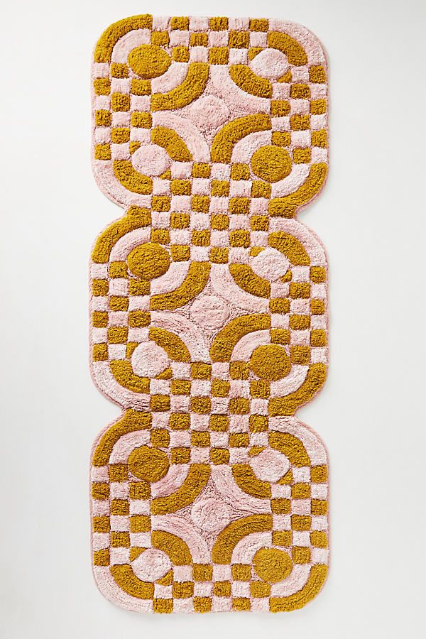 two yellow and pink rugs sitting on top of a white floor next to each other