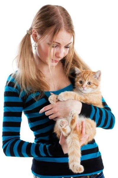 a woman holding a cat in her arms