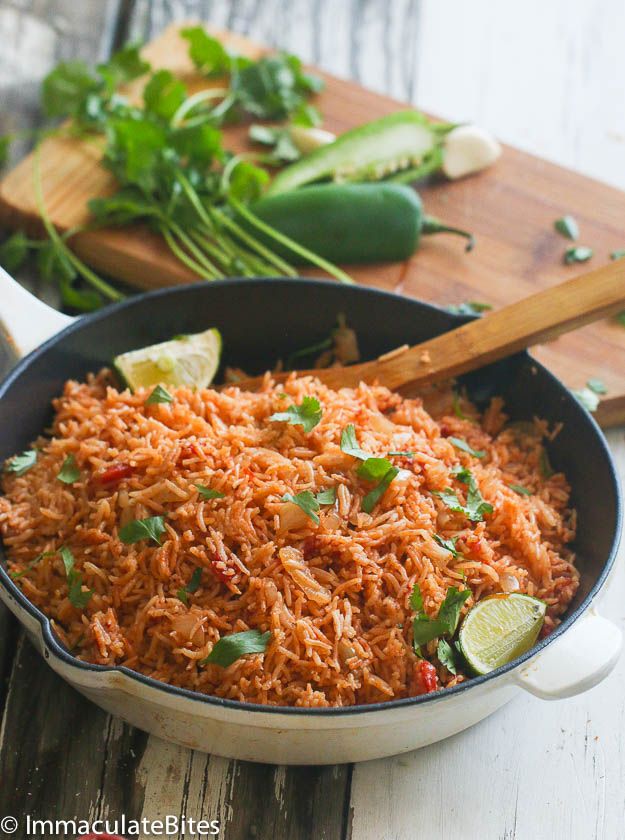 mexican rice in a skillet with limes and cilantro on the side