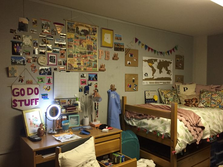 a dorm room with a bed, desk and other things on the wall above it