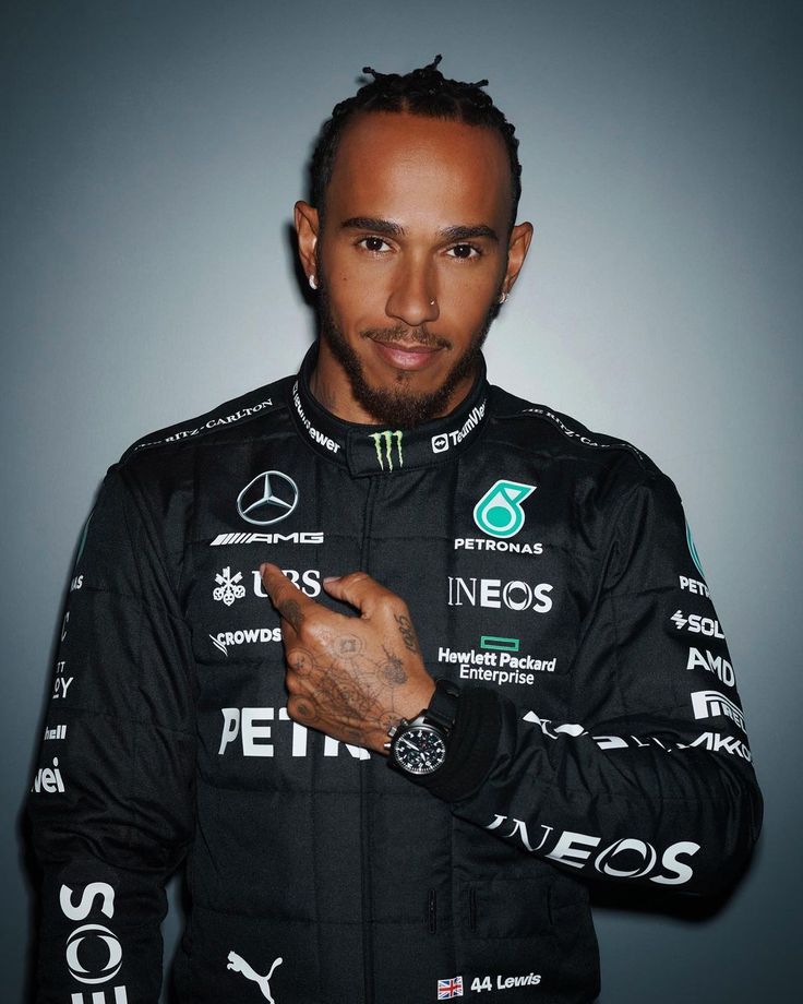 a man in a racing suit is posing for a photo with his hand on his hip