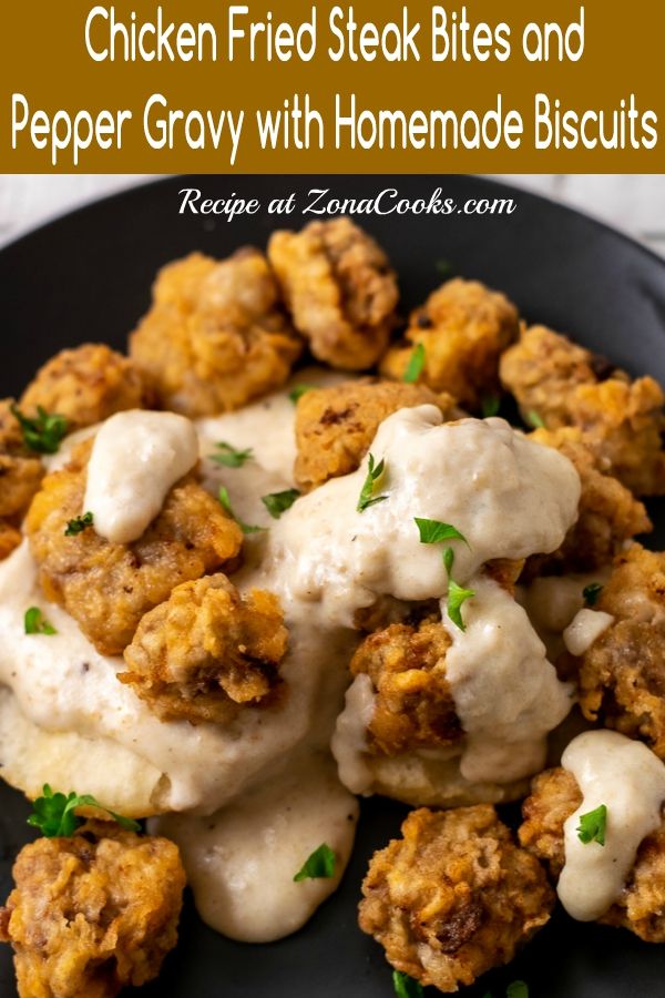 chicken fried steak bites and pepper gravy with homemade biscuits on a black plate