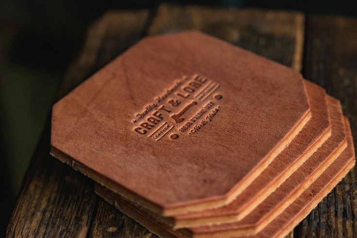 a stack of wooden coasters sitting on top of a wooden table next to each other