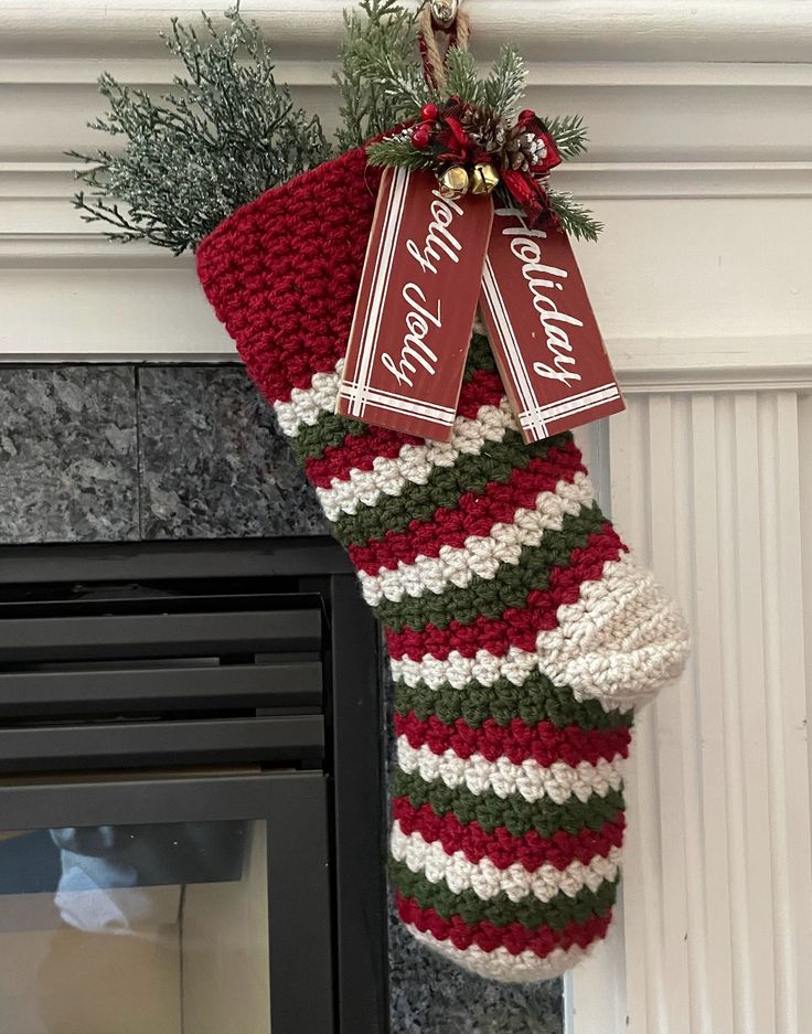 a christmas stocking hanging from the fireplace with two tags on it's side