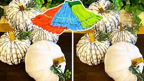 three white pumpkins sitting on top of a wooden table with an umbrella over them