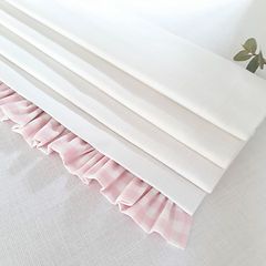 pink and white bedding with ruffles on the bottom