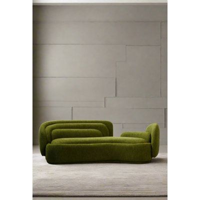 a green couch sitting on top of a white floor next to a wall in an empty room