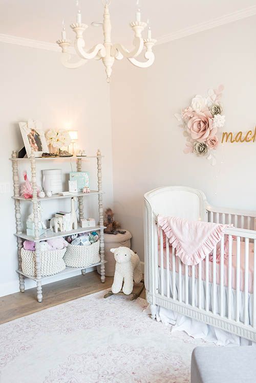 a baby's room with a crib, chandelier and stuffed animals