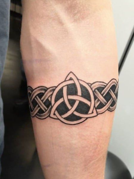 a man with a tattoo on his arm that has an interlaced design on it