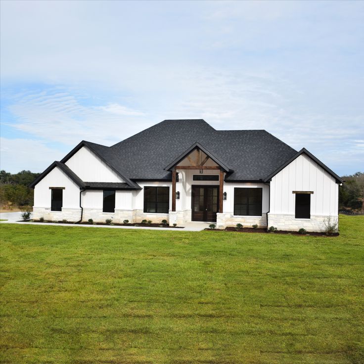 a large white house sitting on top of a lush green field