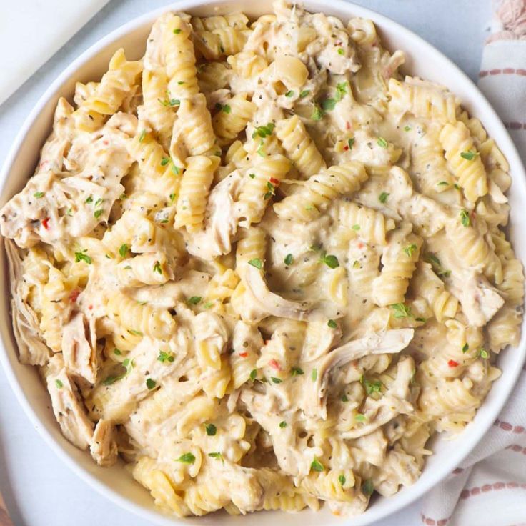 a white bowl filled with pasta and chicken