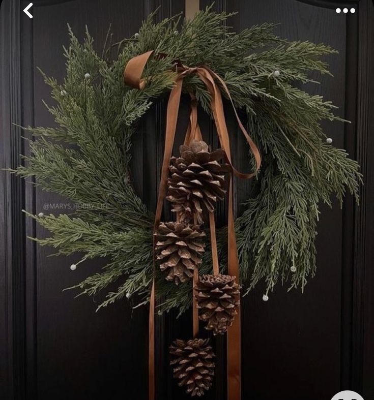 a wreath with pine cones hanging from it