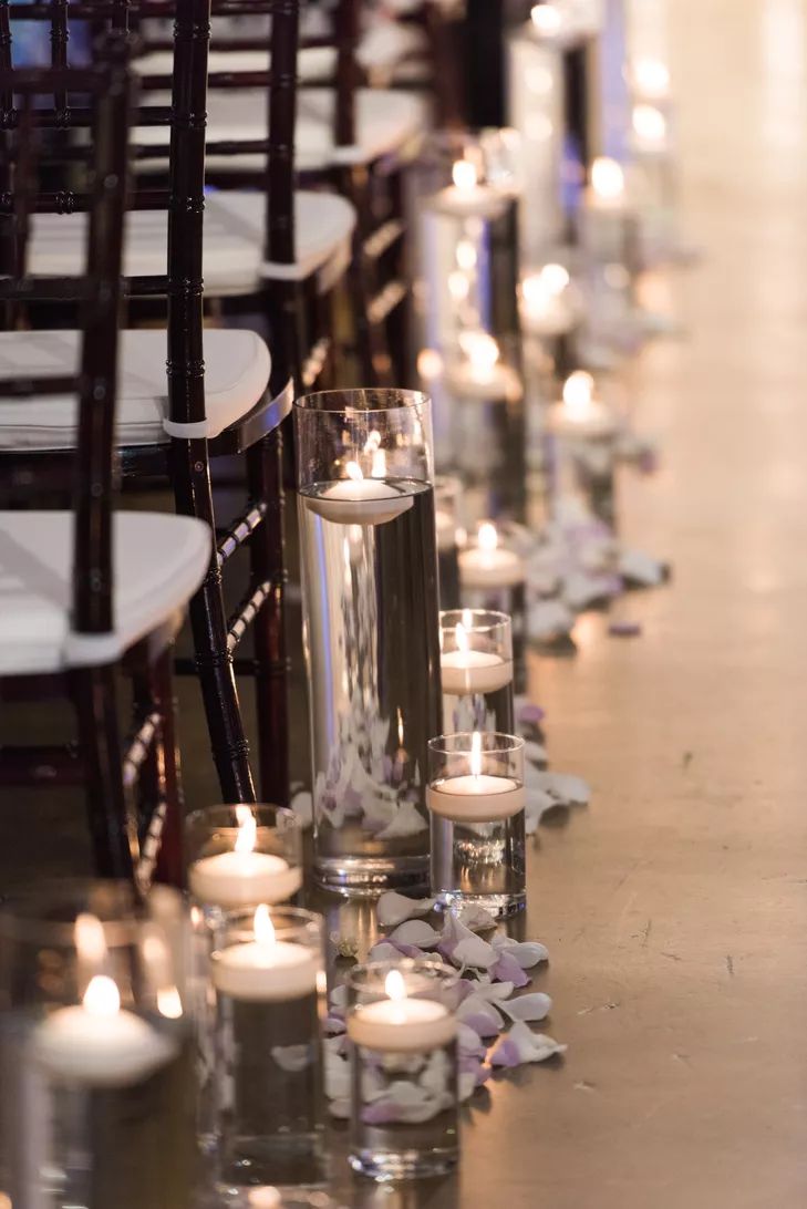 rows of candles are lined up on the floor in front of an aisle with chairs