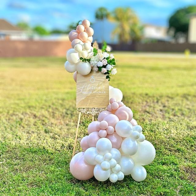 a bunch of balloons in the shape of a pyramid on top of a grass field