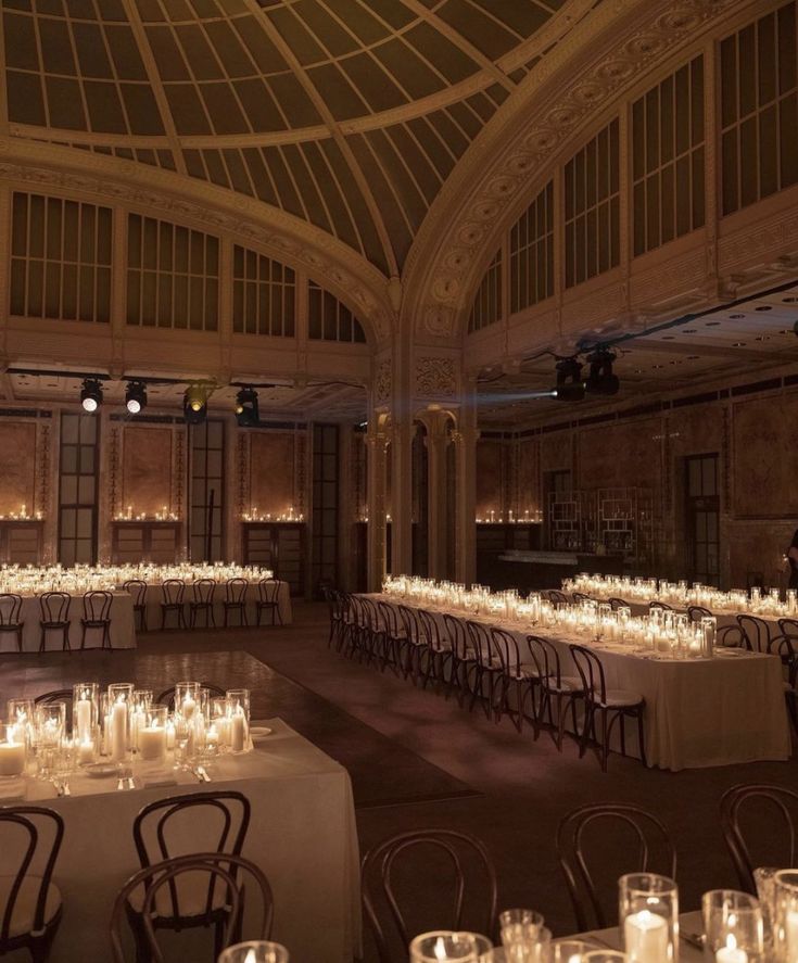 a large room with tables and chairs covered in candles