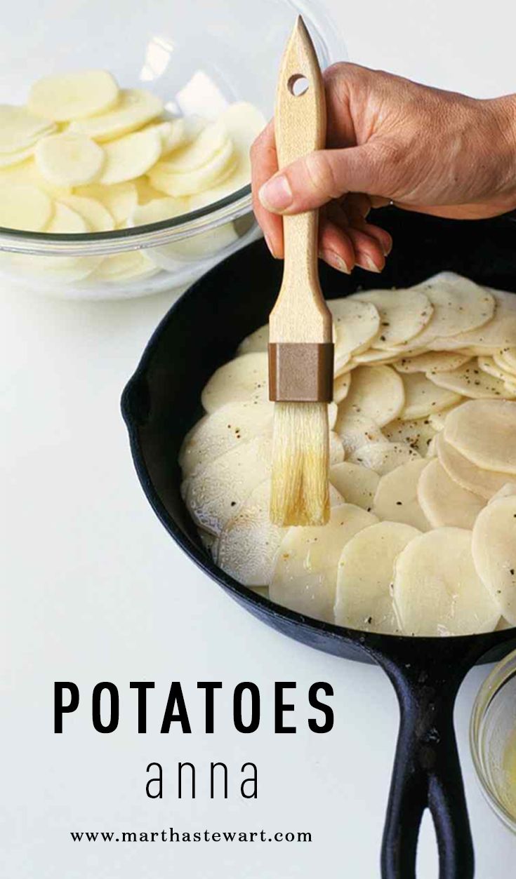 a pan filled with sliced potatoes being stirred by a wooden spatula on top of it