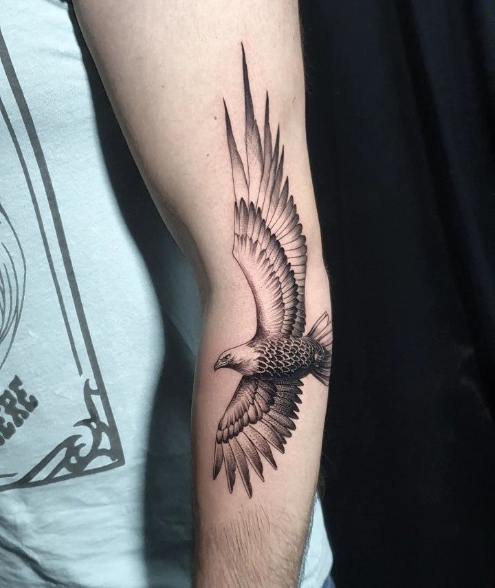 a man's arm with an eagle tattoo on it