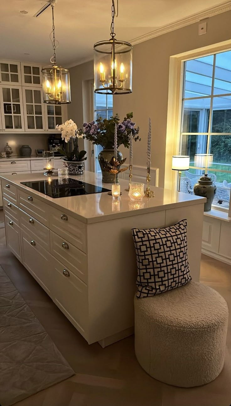 a kitchen with a center island and stools next to the stove top oven in front of a large window