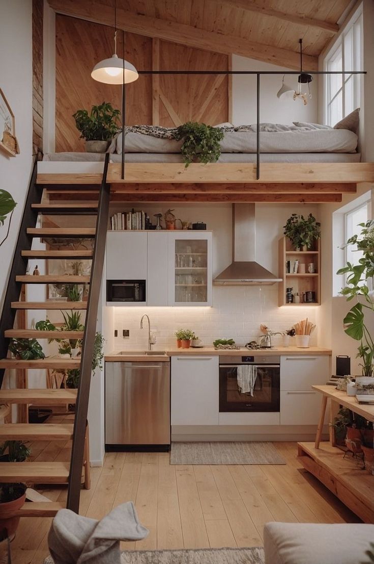 a kitchen and living room with stairs leading up to the upper floor, in a loft style home