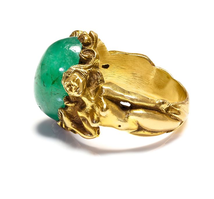 Antique Gold Large Cabochon Emerald Nude Lady Ring Dive into the enchanting realm of Art Nouveau with this magnificent gold ring, a testament to exquisite craftsmanship and artistic vision. This piece features a delicate assembly of sculpted ladies, each figure intertwined gracefully, representing the period's fascination with fluid, natural forms. At the center of this collective beauty sits a striking cabochon emerald, its lush green depths echoing the vibrant life of untouched nature. This si Antique Gold Emerald Ring With Oval Cabochon, Antique Emerald Ring In Gold With Oval Cabochon, Antique Gold Emerald Cabochon Ring, Gold Art Nouveau Jewelry With Intaglio, Art Nouveau Yellow Gold Collectible Rings, Art Nouveau Yellow Gold Ring, Collectible Yellow Gold Emerald Cabochon Ring, Collectible Yellow Gold Emerald Ring With Cabochon, Collectible Art Nouveau Yellow Gold Ring