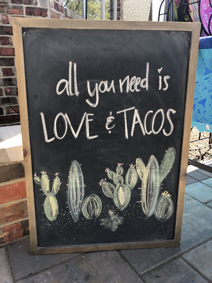 a chalkboard sign that says all you need is love and tacos