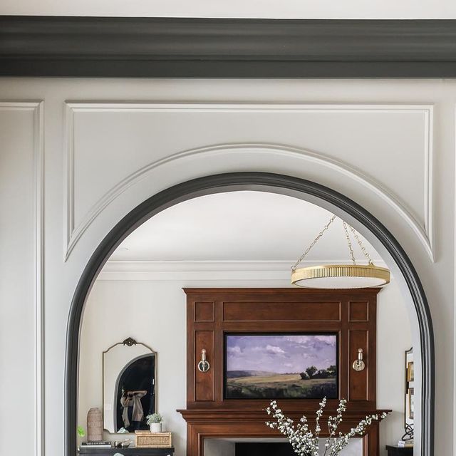 an arched doorway leading to a living room filled with furniture and art on the walls