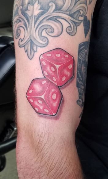 two red dices sitting on top of each other next to a black and white tattoo