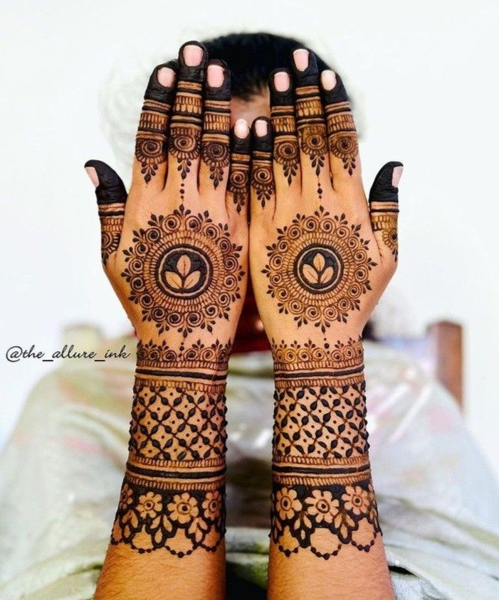 a woman's hands with henna tattoos on them