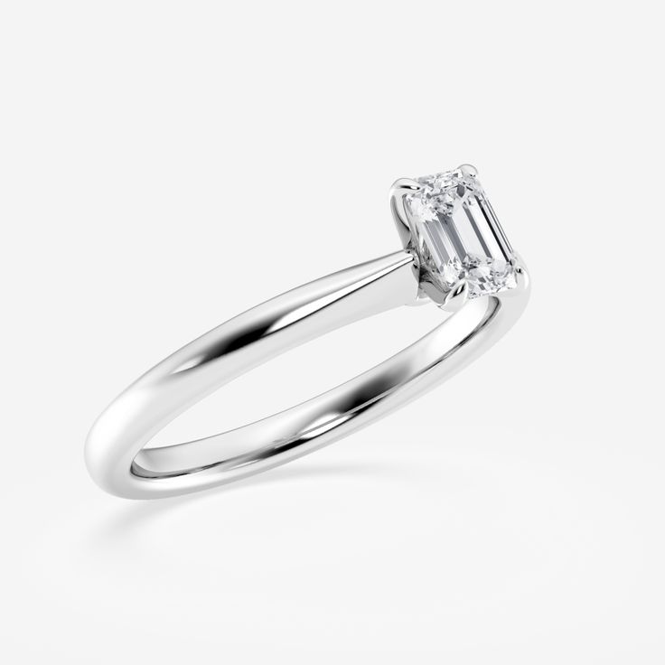 a white gold engagement ring with an emerald cut diamond