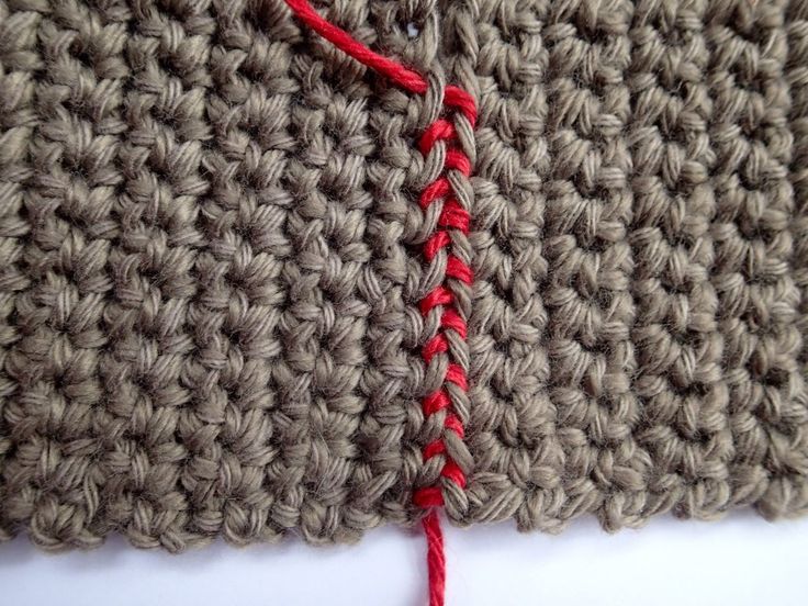 a crocheted piece of cloth with a red thread on the end that has been stitched together