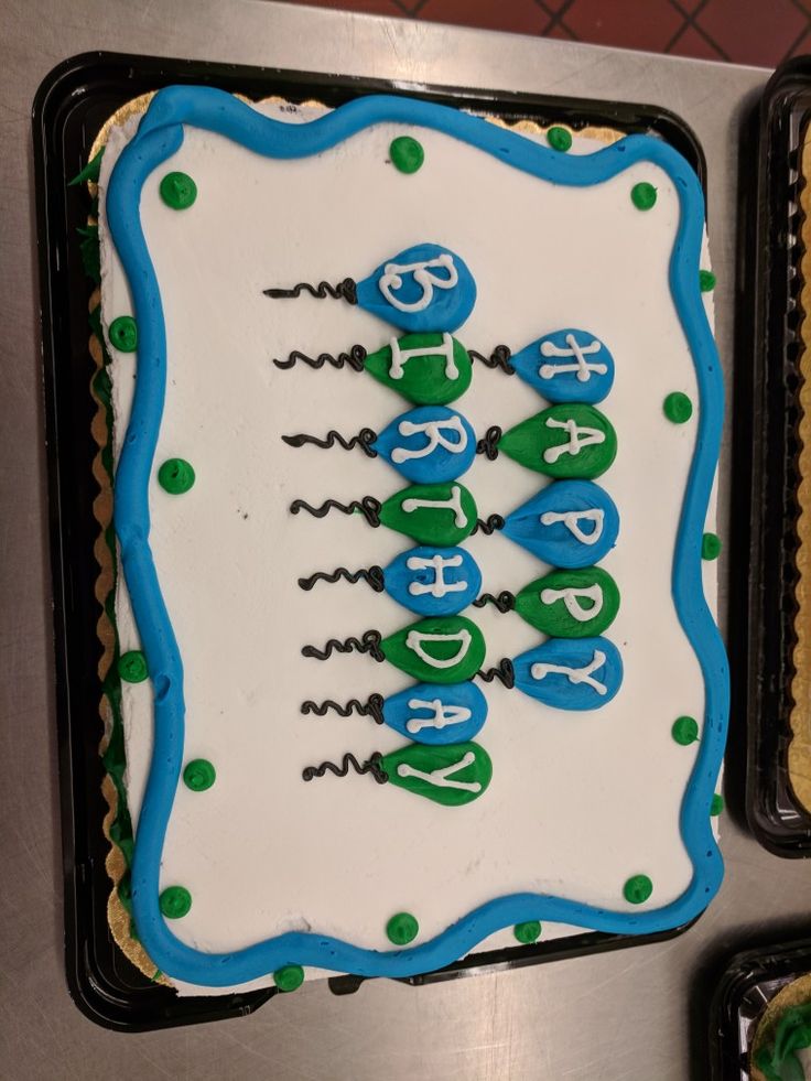 a birthday cake with blue and green icing on it's side is displayed