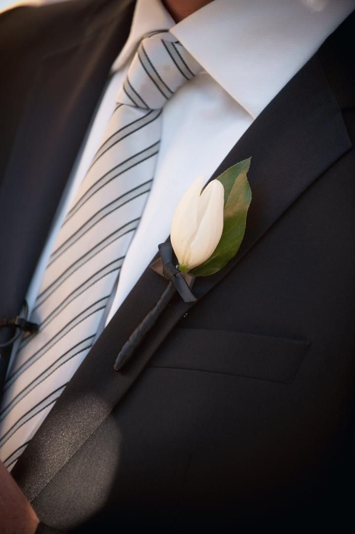 a man wearing a suit and tie with a boutonniere on his lapel