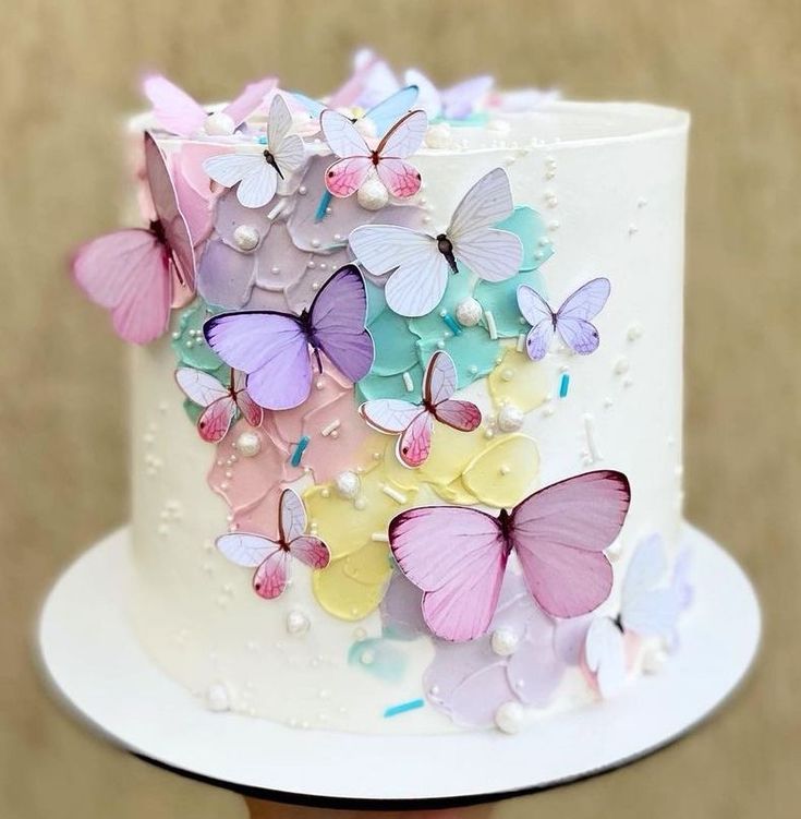 there is a white cake with many colorful butterflies on the frosting and icing