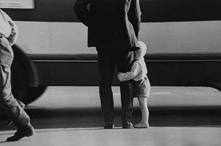 a man standing next to a little boy in front of an airplane