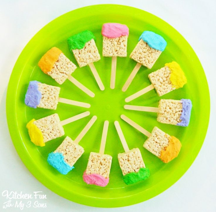 marshmallow pops are arranged in a circle on a green plate with white background