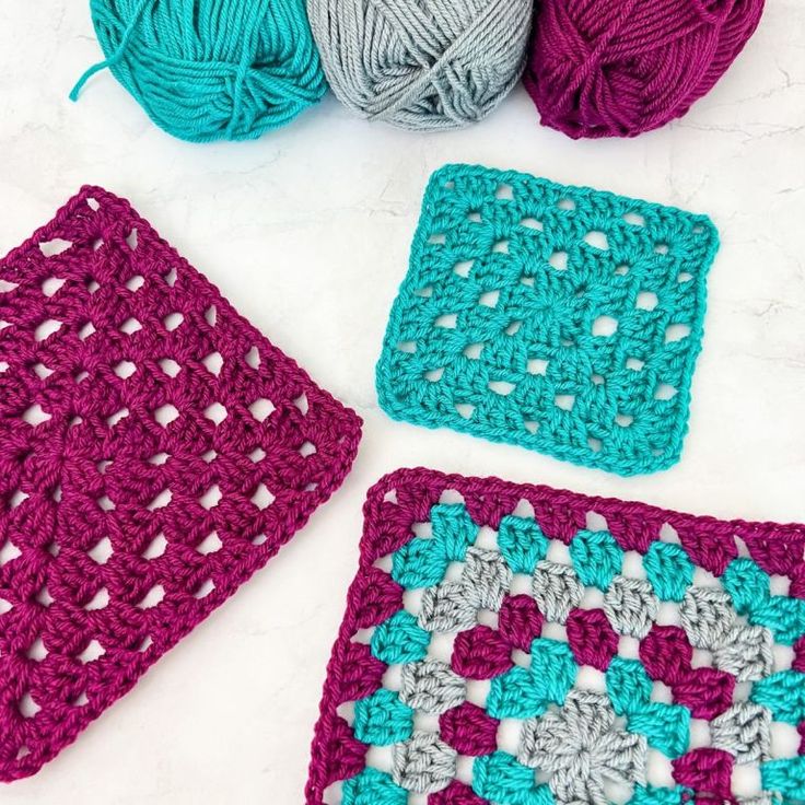 crocheted squares and balls of yarn on a table