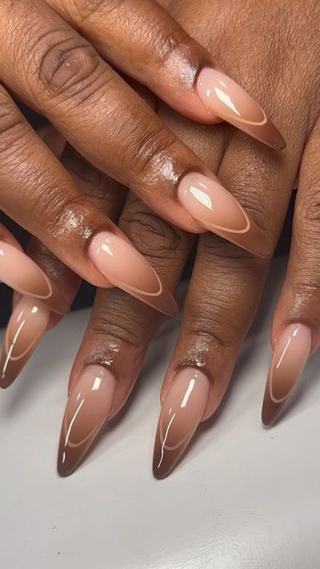 a woman's hands with long, shiny nails and nude colored nail polishes