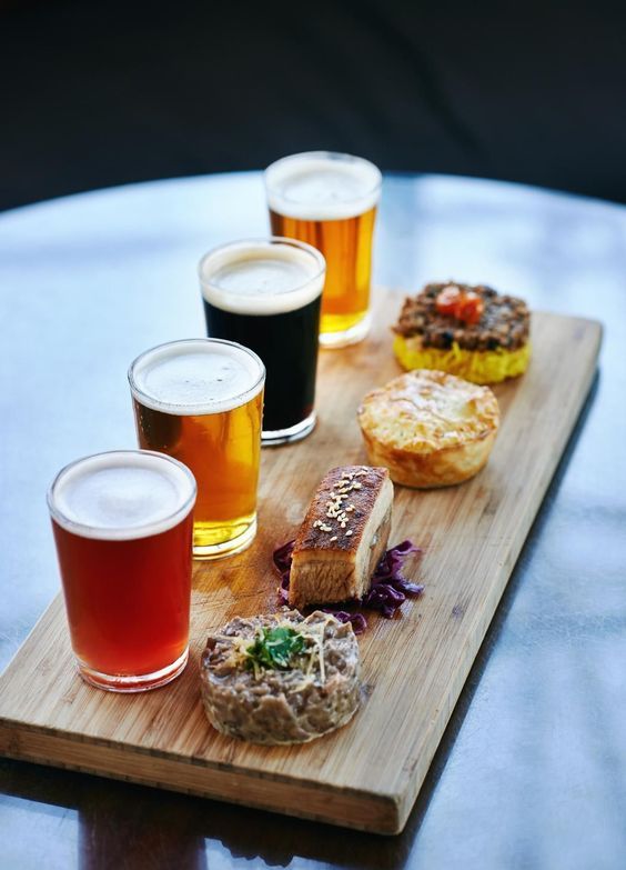 a wooden tray topped with different types of food and drinks