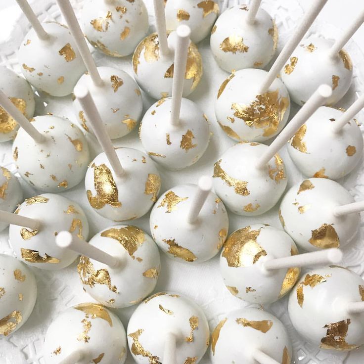 white and gold cake pops on a plate