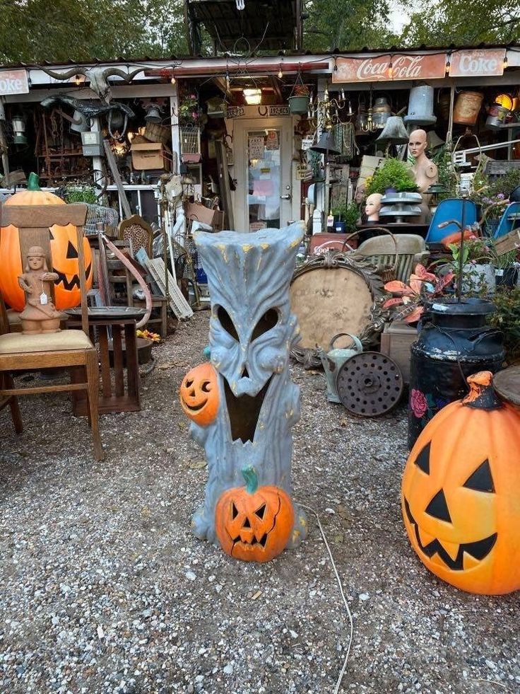 two carved pumpkins sitting next to each other in front of a building with lots of junk