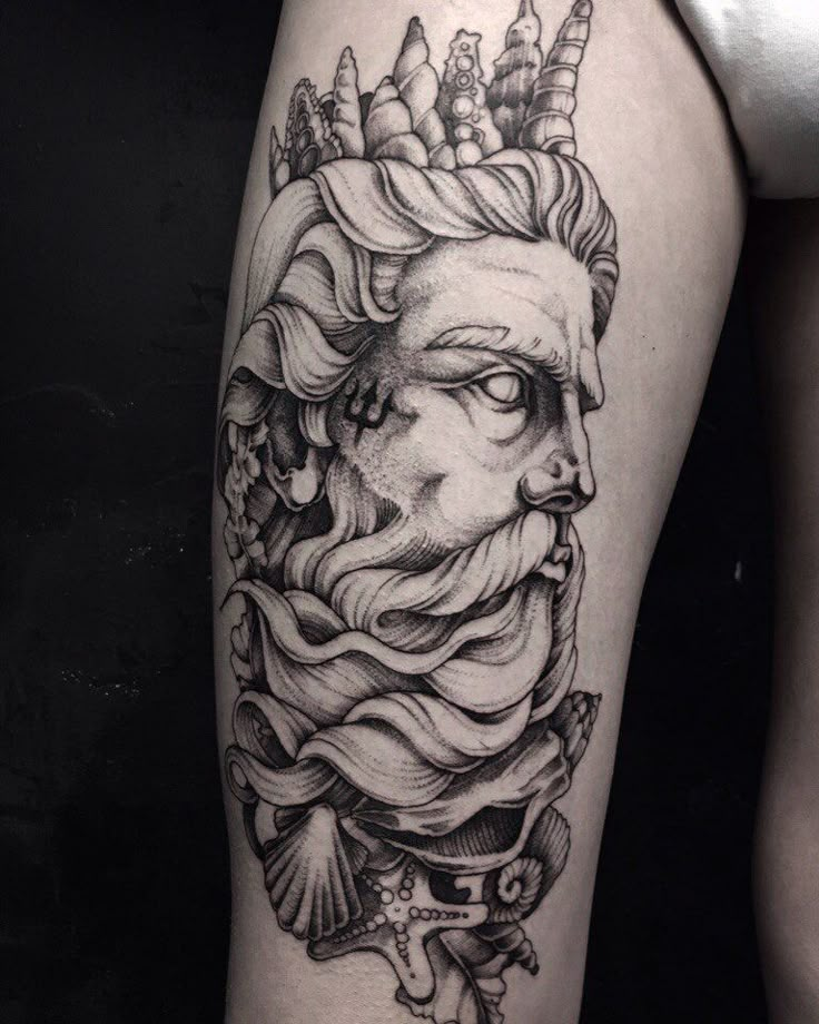 a woman's thigh with a black and white tattoo design on her leg that has an image of a lion wearing a crown