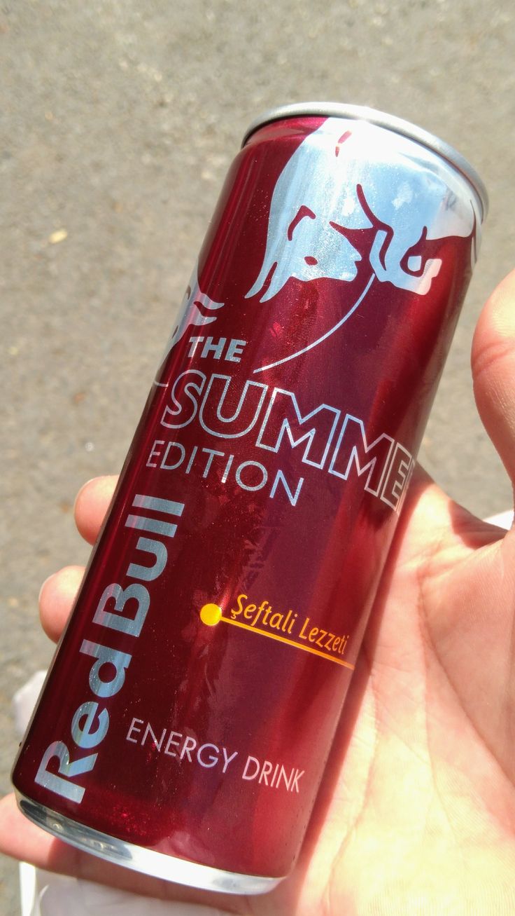 a person holding a can of red bull energy drink