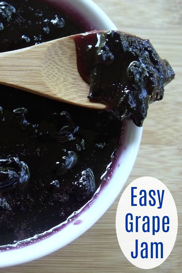 blueberry jam in a white bowl with a wooden spoon on top and the words easy grape jam below it