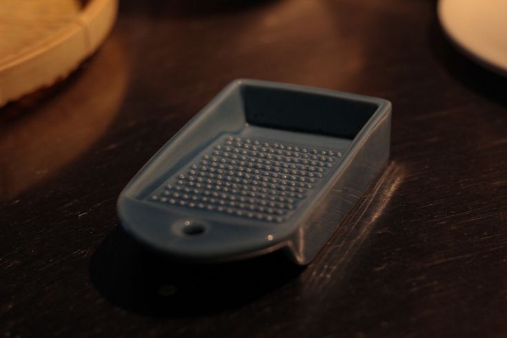 a close up of a plastic container on a table with other dishes in the background