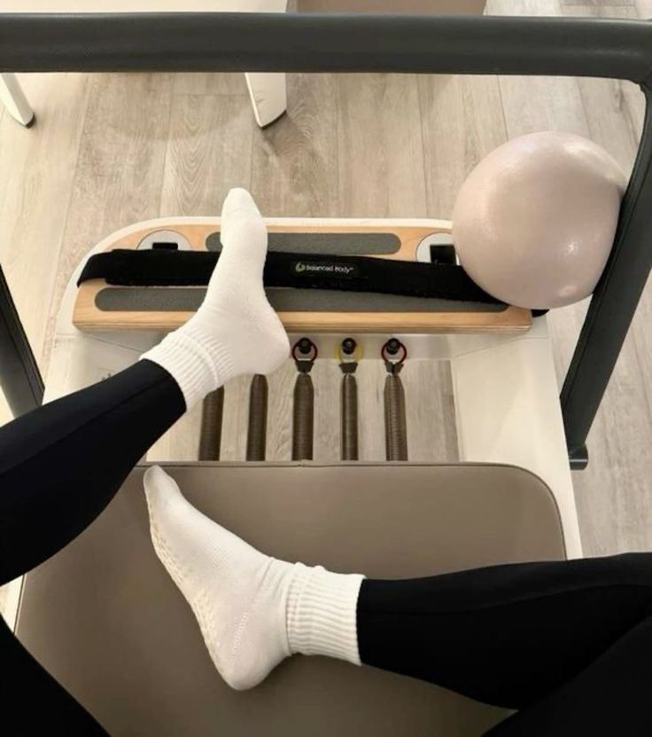 a person is sitting on a chair with their feet in the air while using an exercise machine