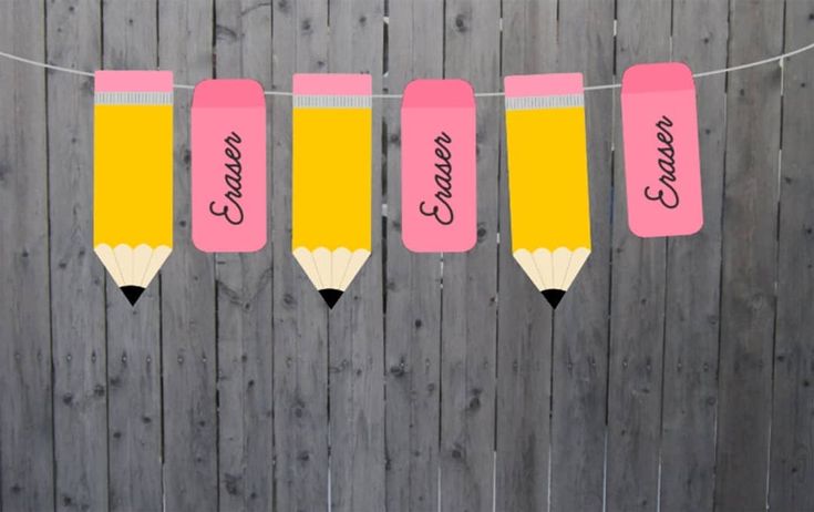 pink and yellow pencils are hanging on a string