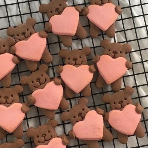 some heart shaped cookies on a cooling rack with teddy bears in the shape of hearts